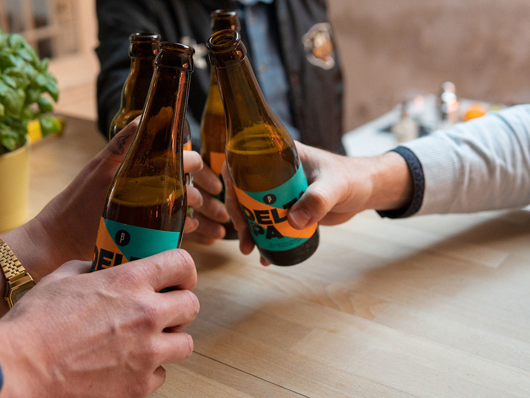 Groupe de personnes trinquant une bière à la main à l'occasion de leur teambuilding