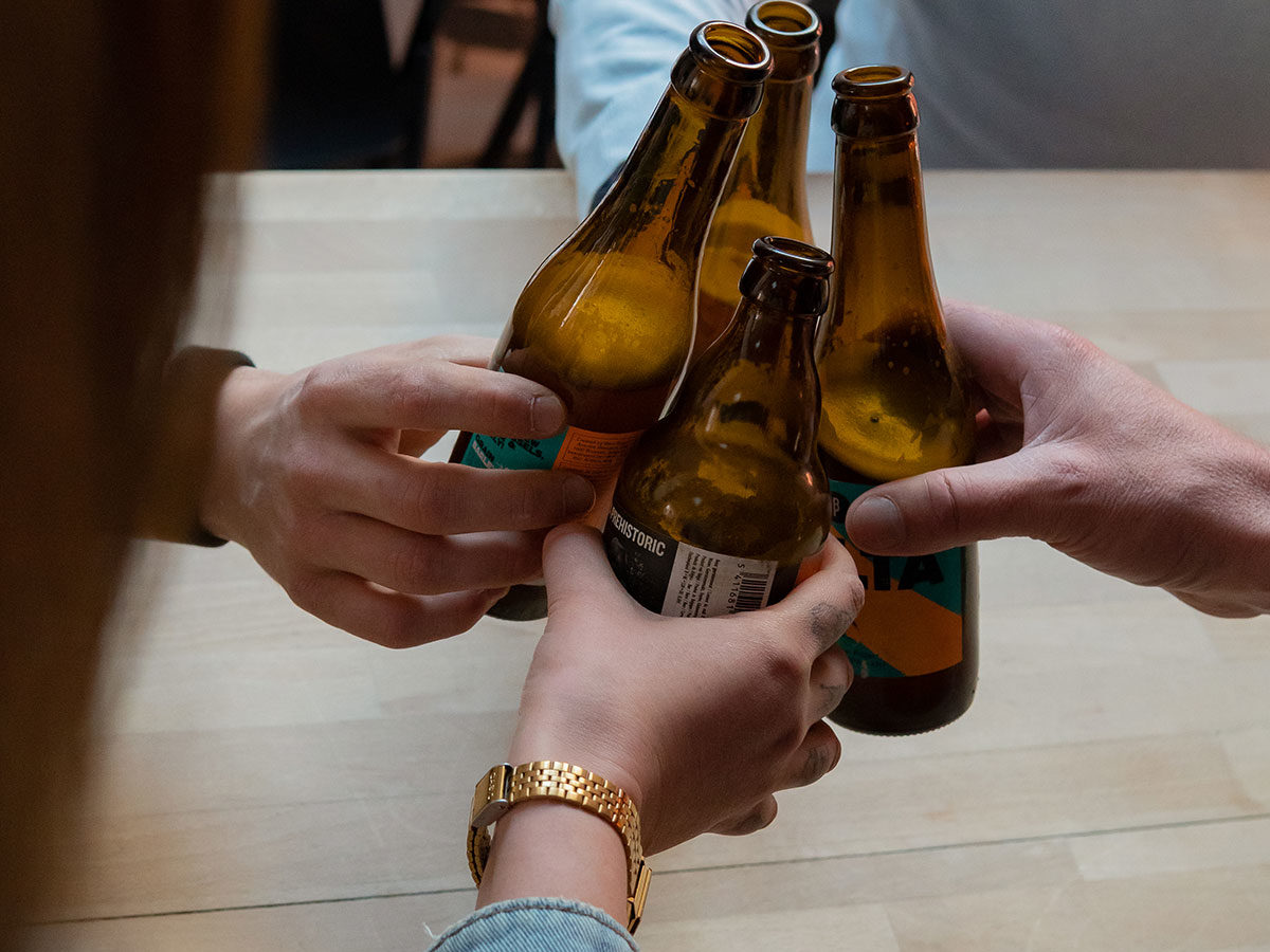 Groupe de personnes trinquant une bière à la main à l'occasion de leur teambuilding