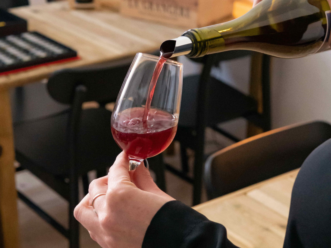 L'animateur de la dégustation de vins sert un verre à un participant