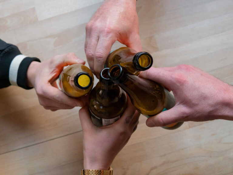 Groupe de personnes trinquant une bière à la main à l'occasion de leur teambuilding