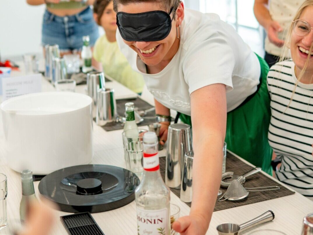 Personne aux yeux bandés en train de réaliser un cocktail