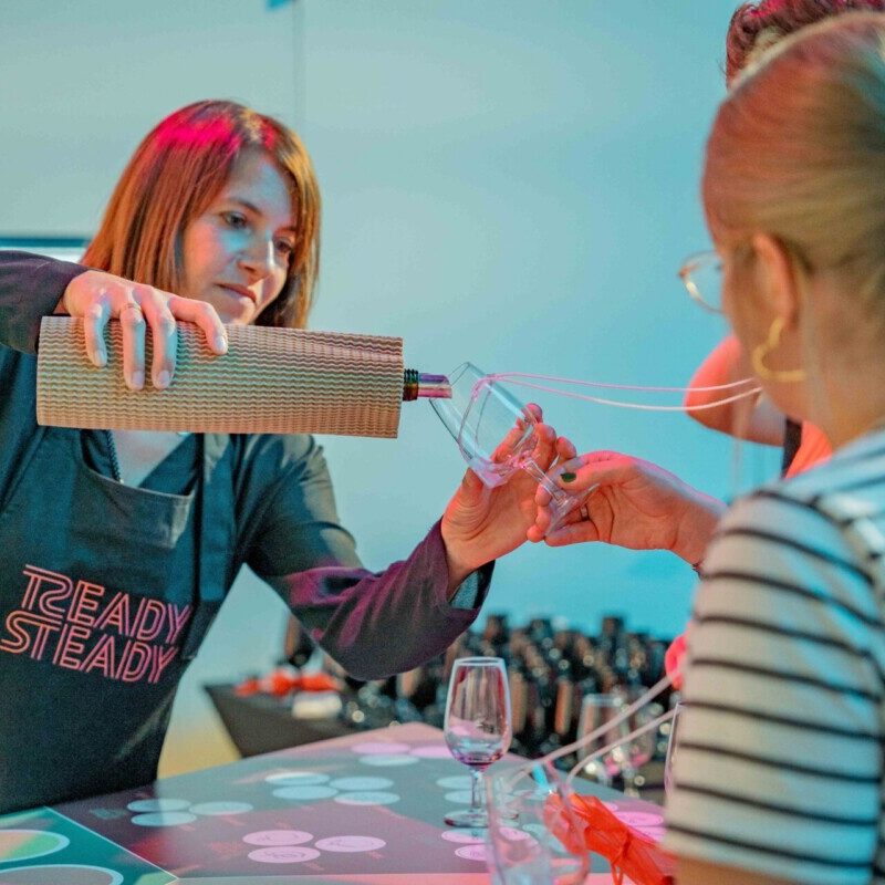 Vanessa Jarlot de Ready Steady en train de verser un verre de vin lors d'une animation d'entreprise
