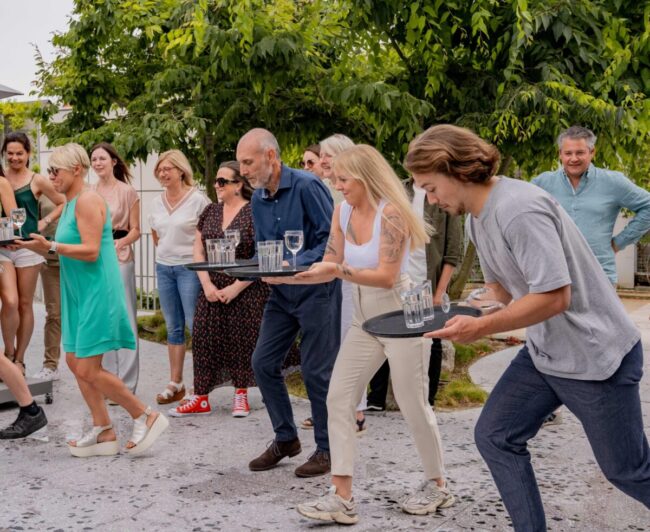 Jeu d'animation Ready Steady avec un groupe de personnes courant sans faire tomber des verres sur un plateau