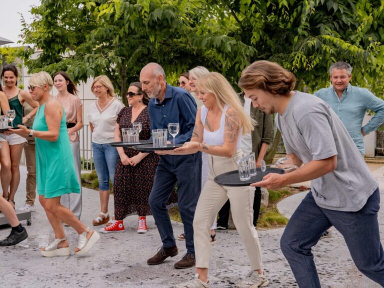 Jeu d'animation Ready Steady avec un groupe de personnes courant sans faire tomber des verres sur un plateau