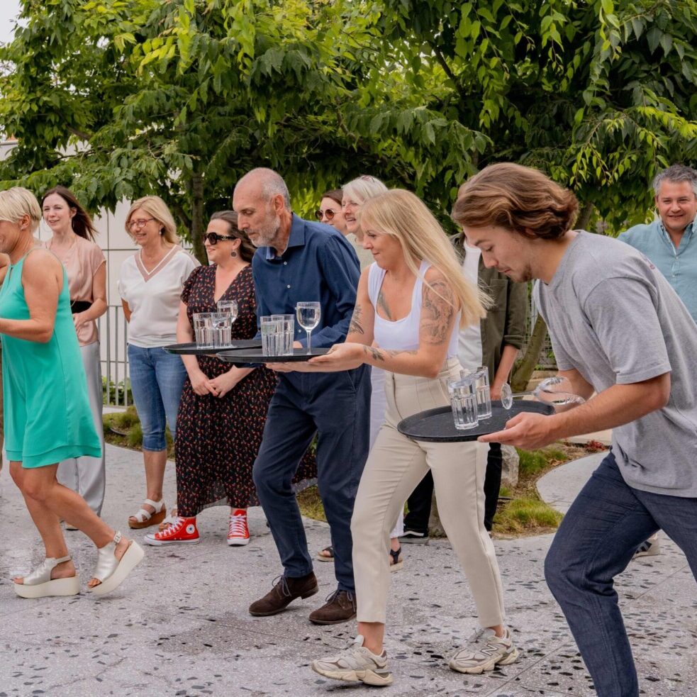 Jeu d'animation Ready Steady avec un groupe de personnes courant sans faire tomber des verres sur un plateau