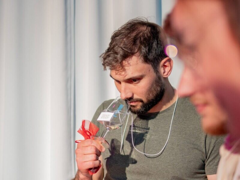 Homme en train de sentir les odeurs d'un vin blanc lors d'une dégustation