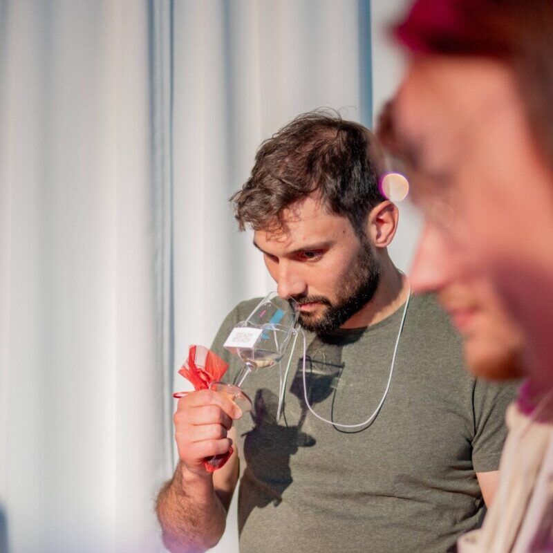 Homme en train de sentir les odeurs d'un vin blanc lors d'une dégustation