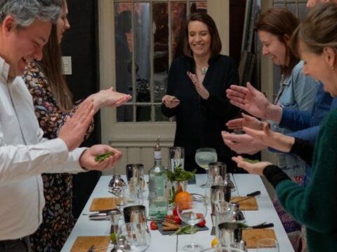 Groupe de personnes autour d'une table en train de faire un team building de création de cocktails
