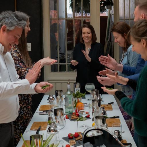 Groupe de personnes autour d'une table en train de faire un team building de création de cocktails