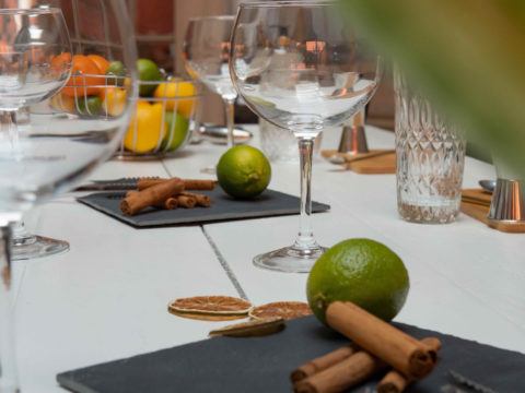Table dressée avec des verres à cocktail, des fruits et des épices pour la préparation de coktails