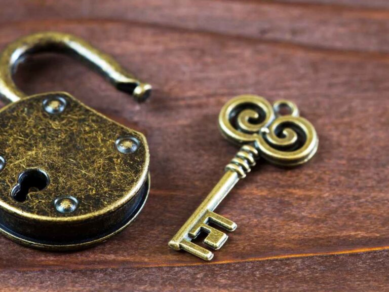 Un cadenas ouvert et une clef sur une table en bois lors d'une activité escape game
