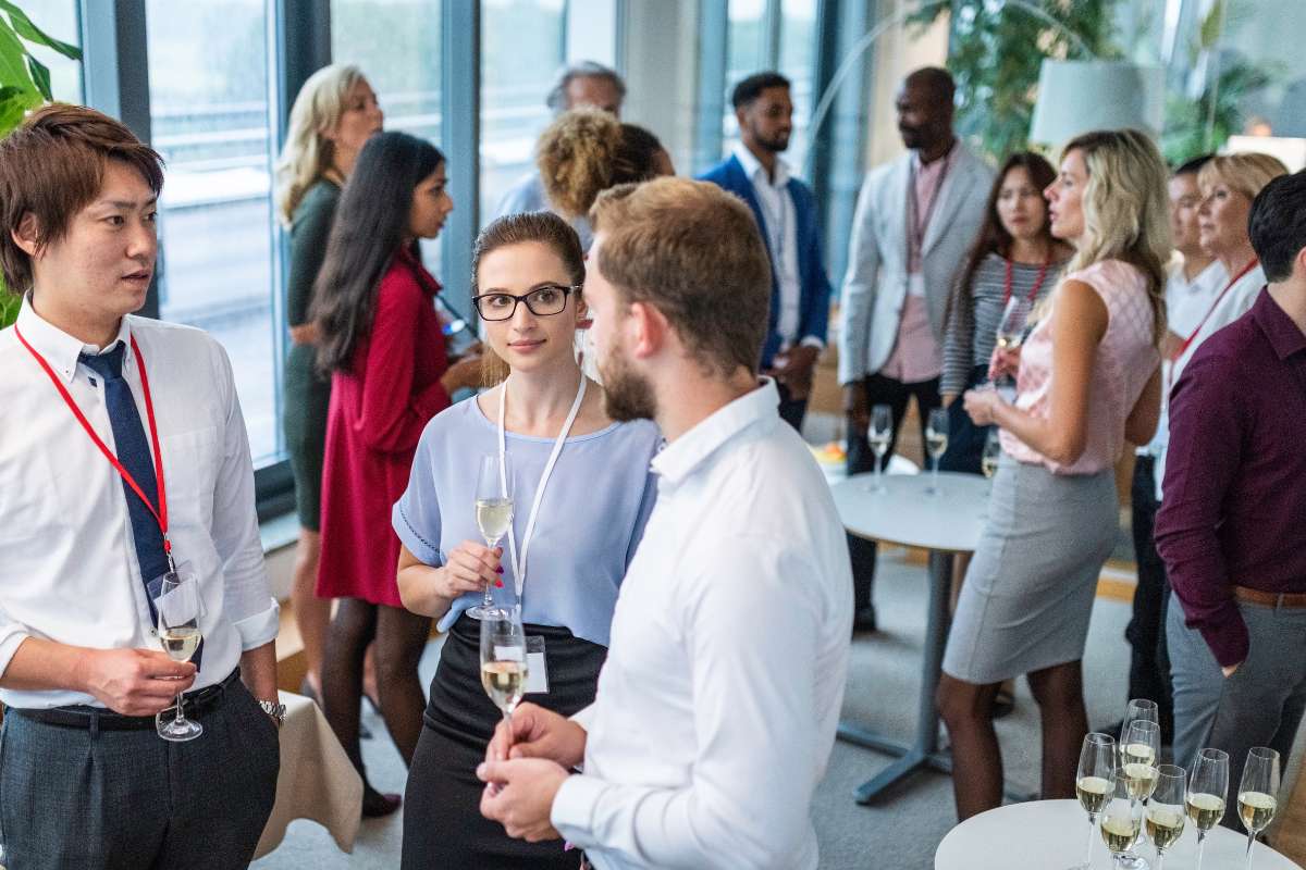 Hommes et femmes lors d'une fête d'entreprise en train de déguster du champagne