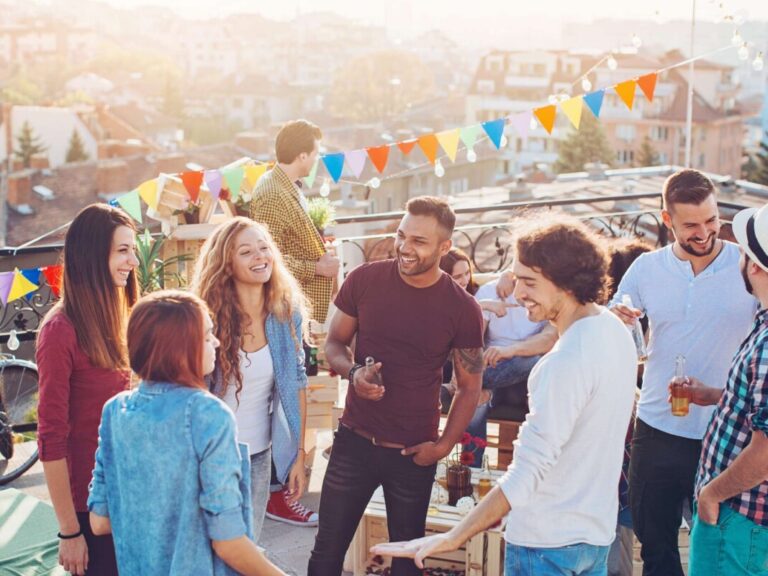 Groupe de collègues sur une terrasse de toit lors d'une fête du personnel de leur entreprise