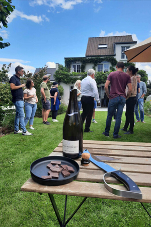 Groupe de personnes dans un jardin lors d'une fête d'anniversaire en train de sabrer le champagne