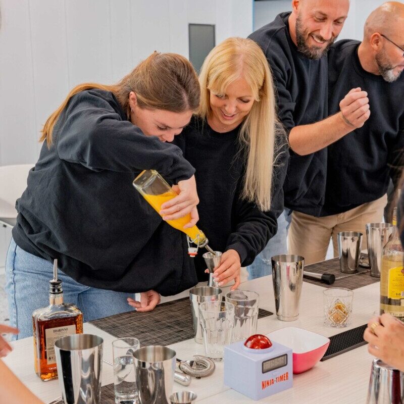 Groupe de personnes autour d'une table en train de réaliser un cocktail challenge