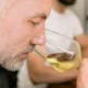 Homme sentant son verre de vin blanc lors d'une initiation à l'œnologie