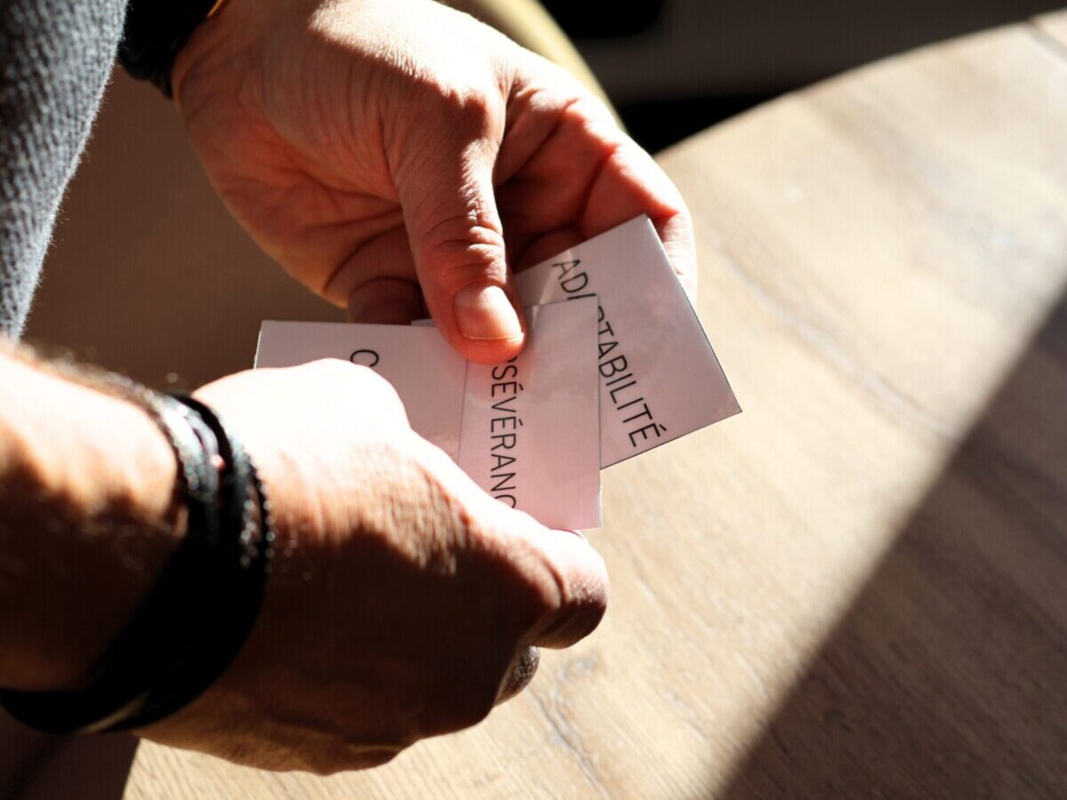 Mains tenant des cartes pour une activité de cohésion d'équipe