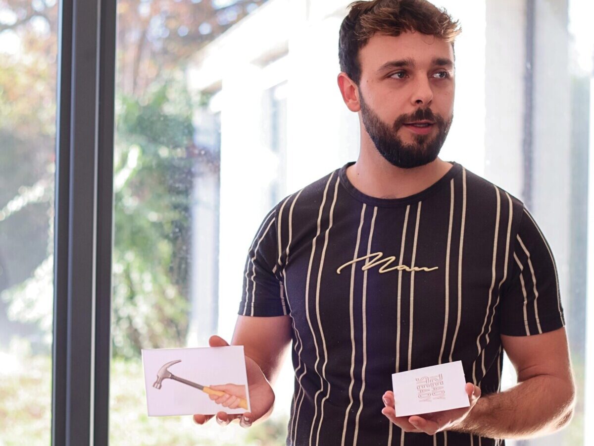 Homme debout montrant des cartes de jeu pour une activité de cohésion d'équipe