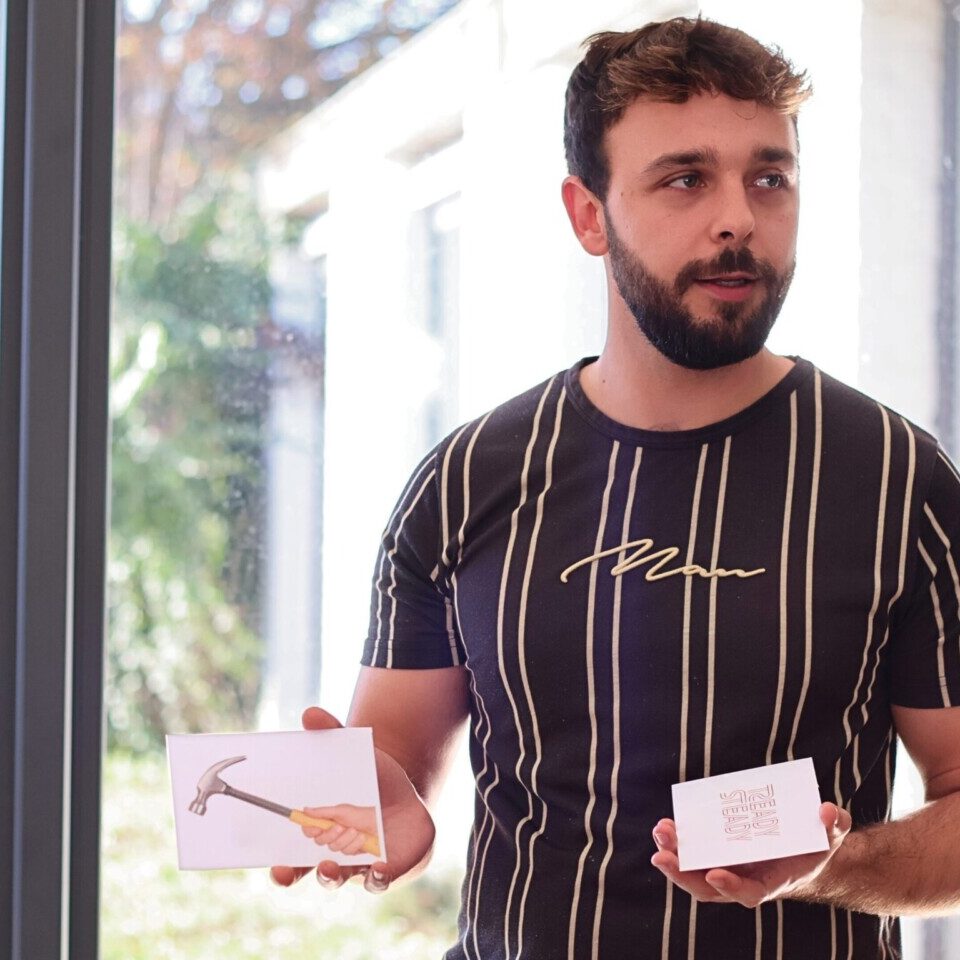 Homme debout montrant des cartes de jeu pour une activité de cohésion d'équipe