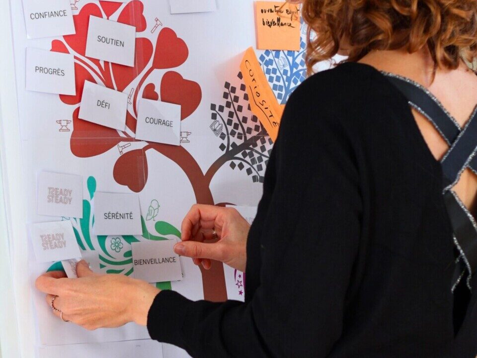 Femme accrochant des pancartes sur une affiche représentant un arbre