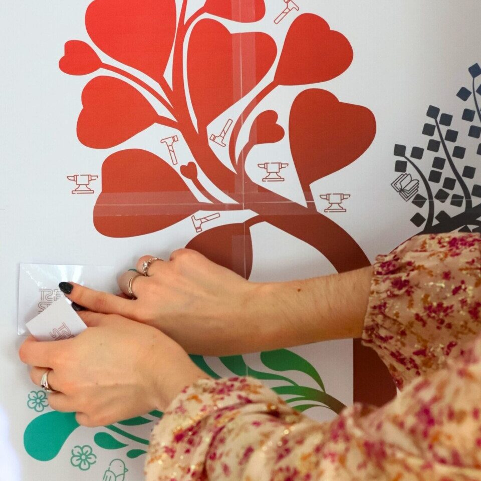Zoom sur des mains collant des stickers sur un mur
